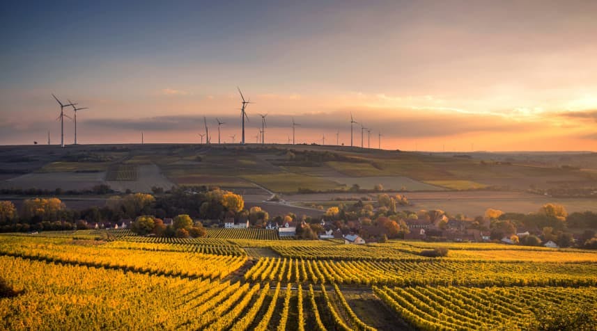 sunset wind turbines over village