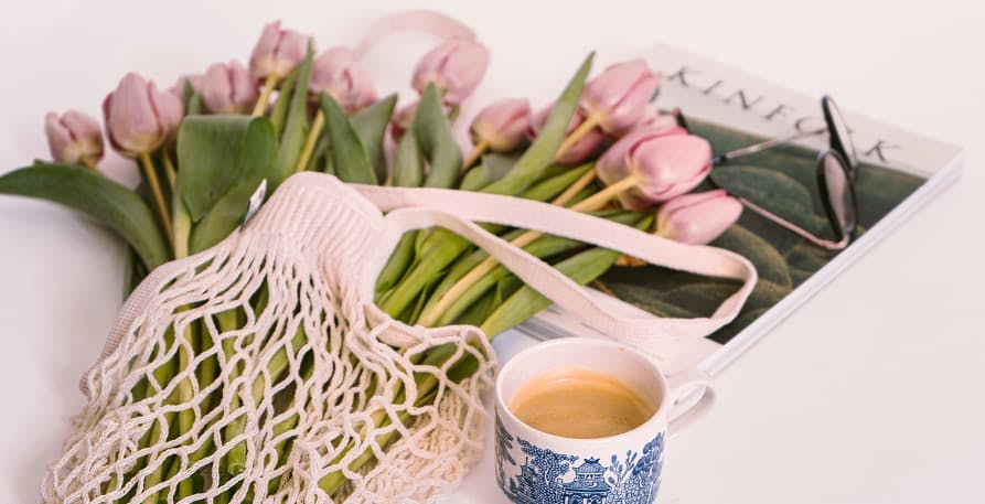 roses in resuable bag next to coffee