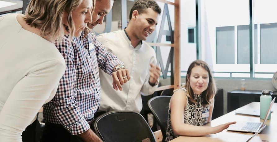employees hovering over a desk