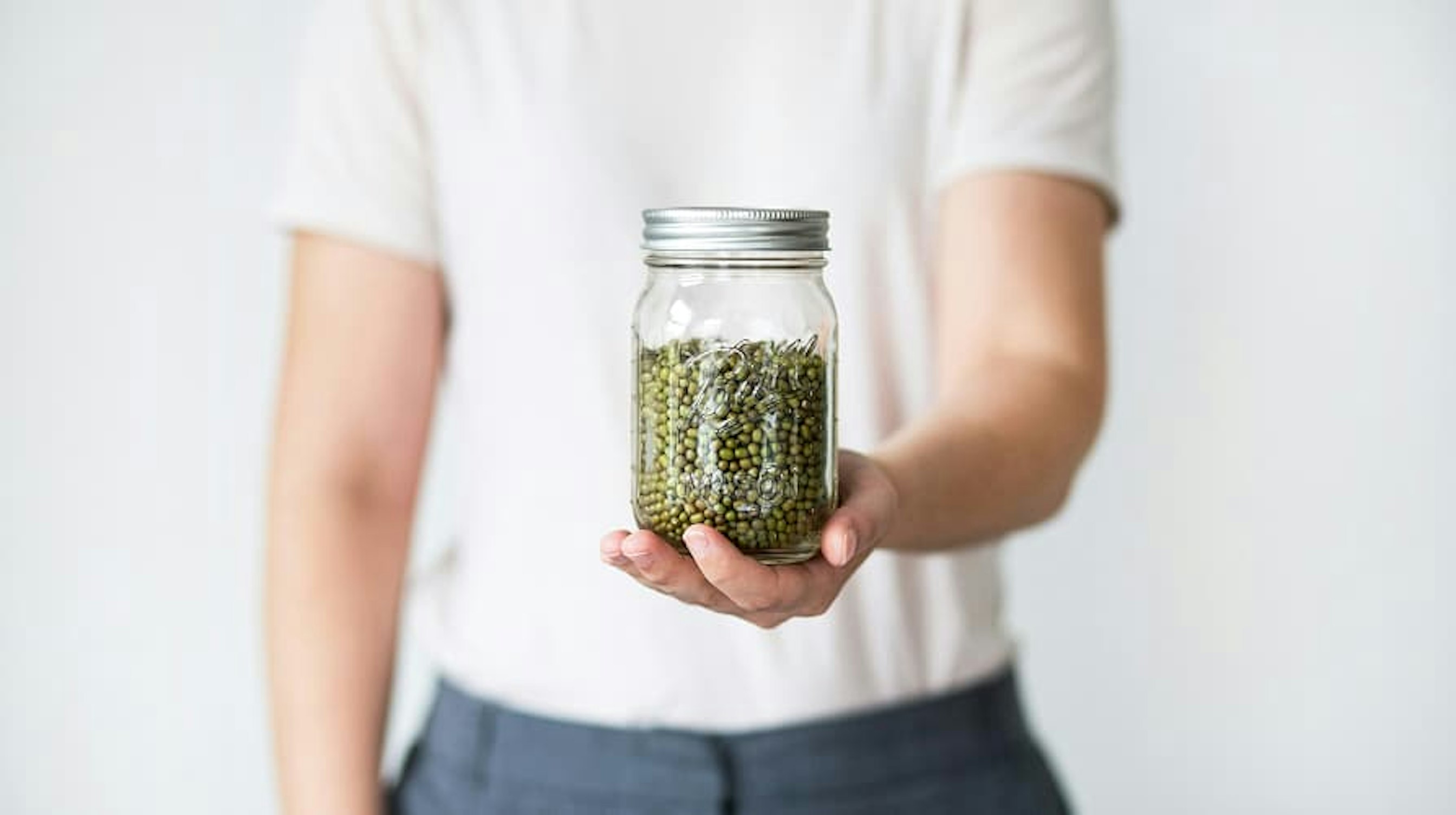 person holding a reusable jar for dried pantry goods