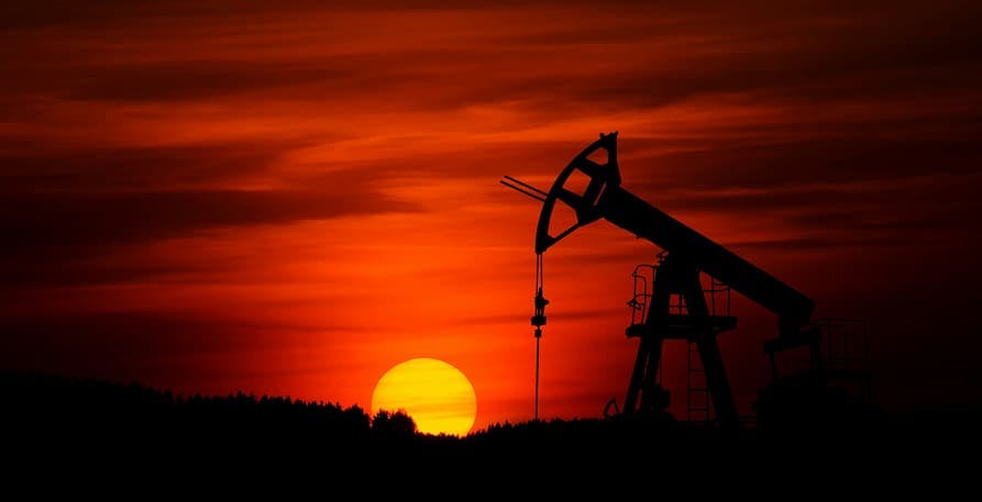 person extracting oil in sunset