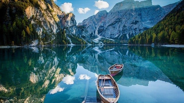 Two boats in a lake surrounded by mountains