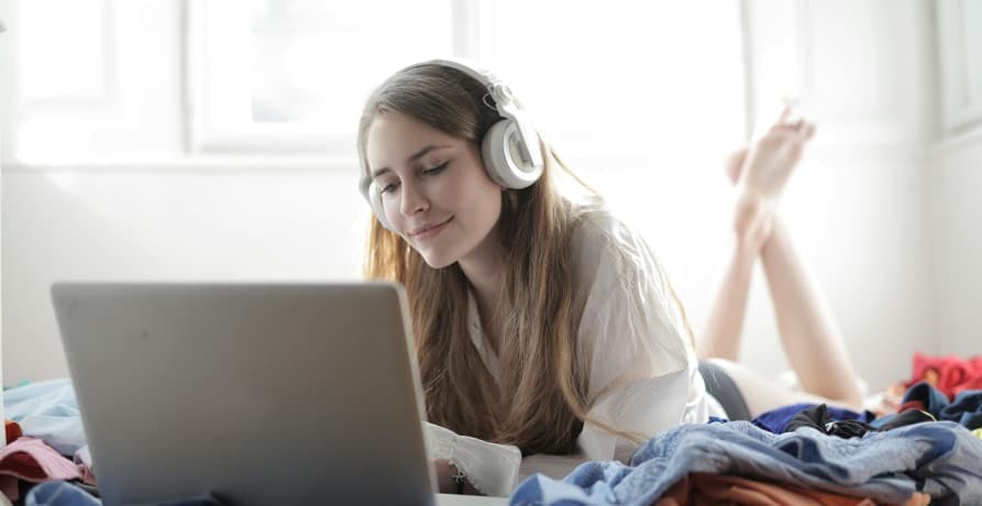 girl listening to music and watching her laptop