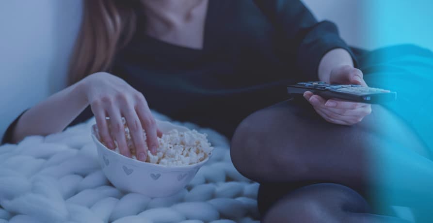 woman watching a movie with some popcorn