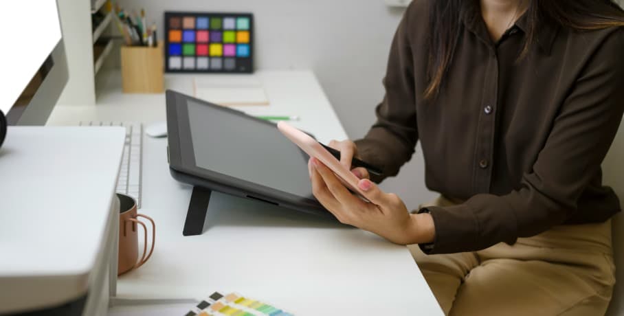 person on smartphone at desk with other devices nearby