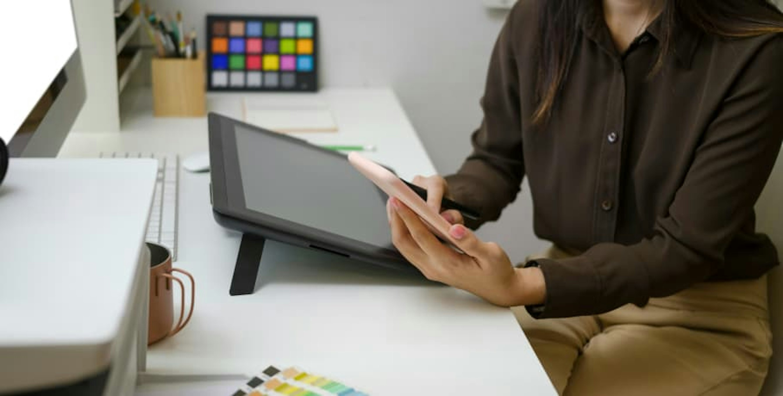 person on smartphone at desk with other devices nearby