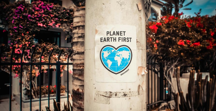 Affiche avec la Terre en forme de coeur, annotée "planet Earth first" ("la planète Terre d'abord")