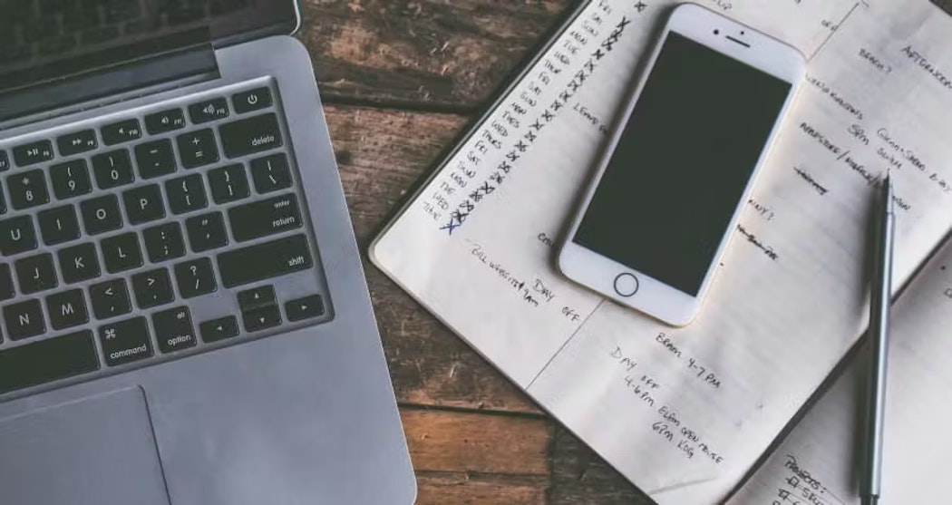 laptop and iphone with notepad