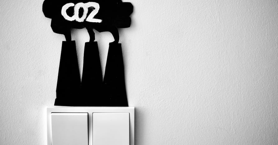 Découpage d'un carton noir en forme d'usines rejetant du CO2