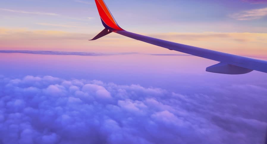 airplane flying at dusk purple skies