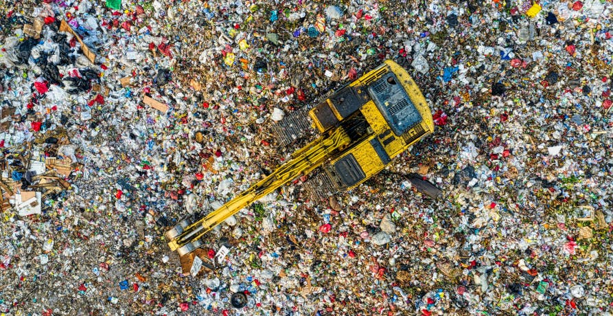 tractopelle au milieu d'une multitude de déchets