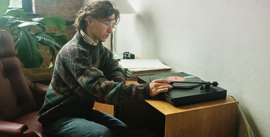 person using record player at table