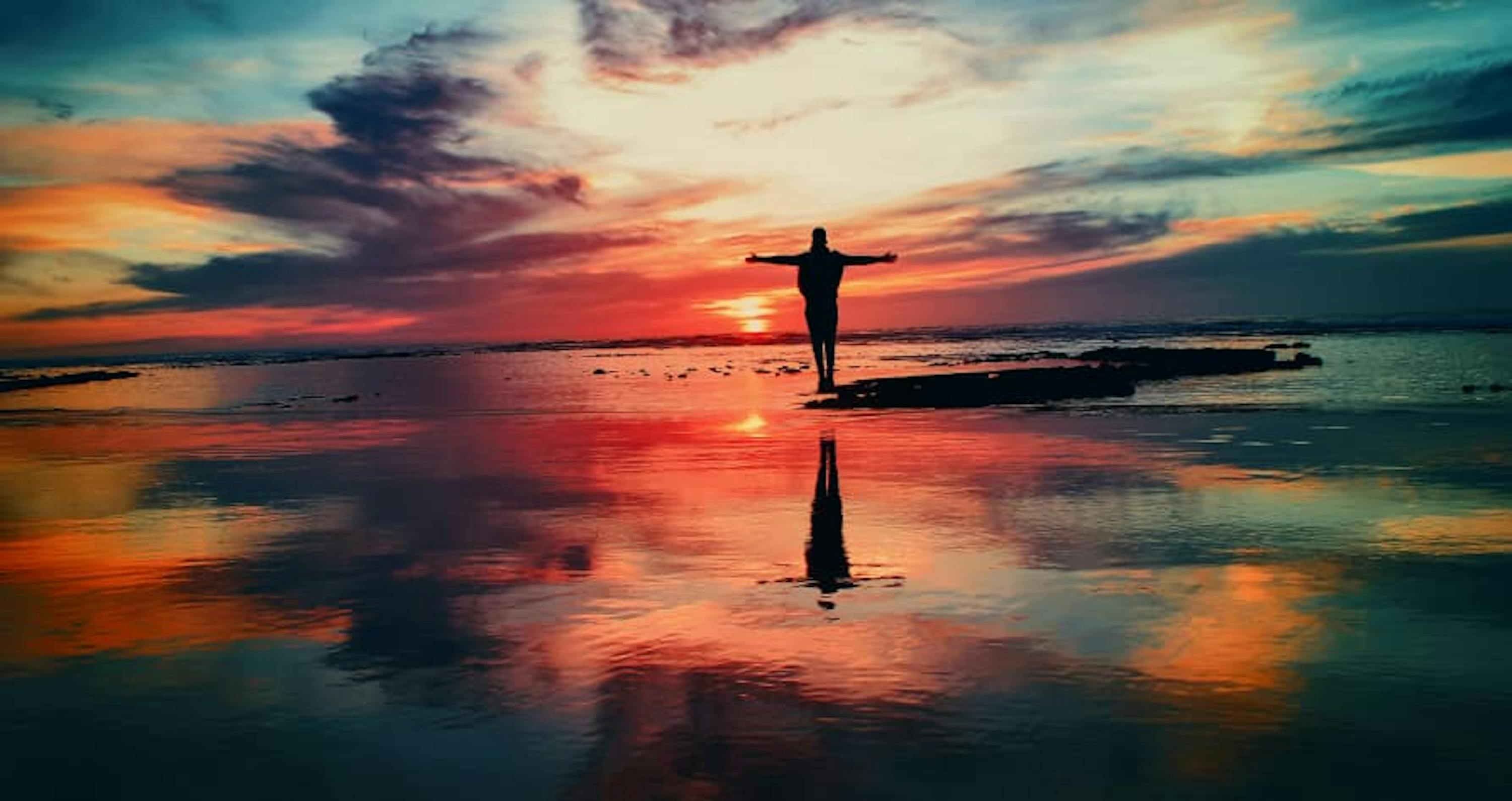 person on beach pink sunset