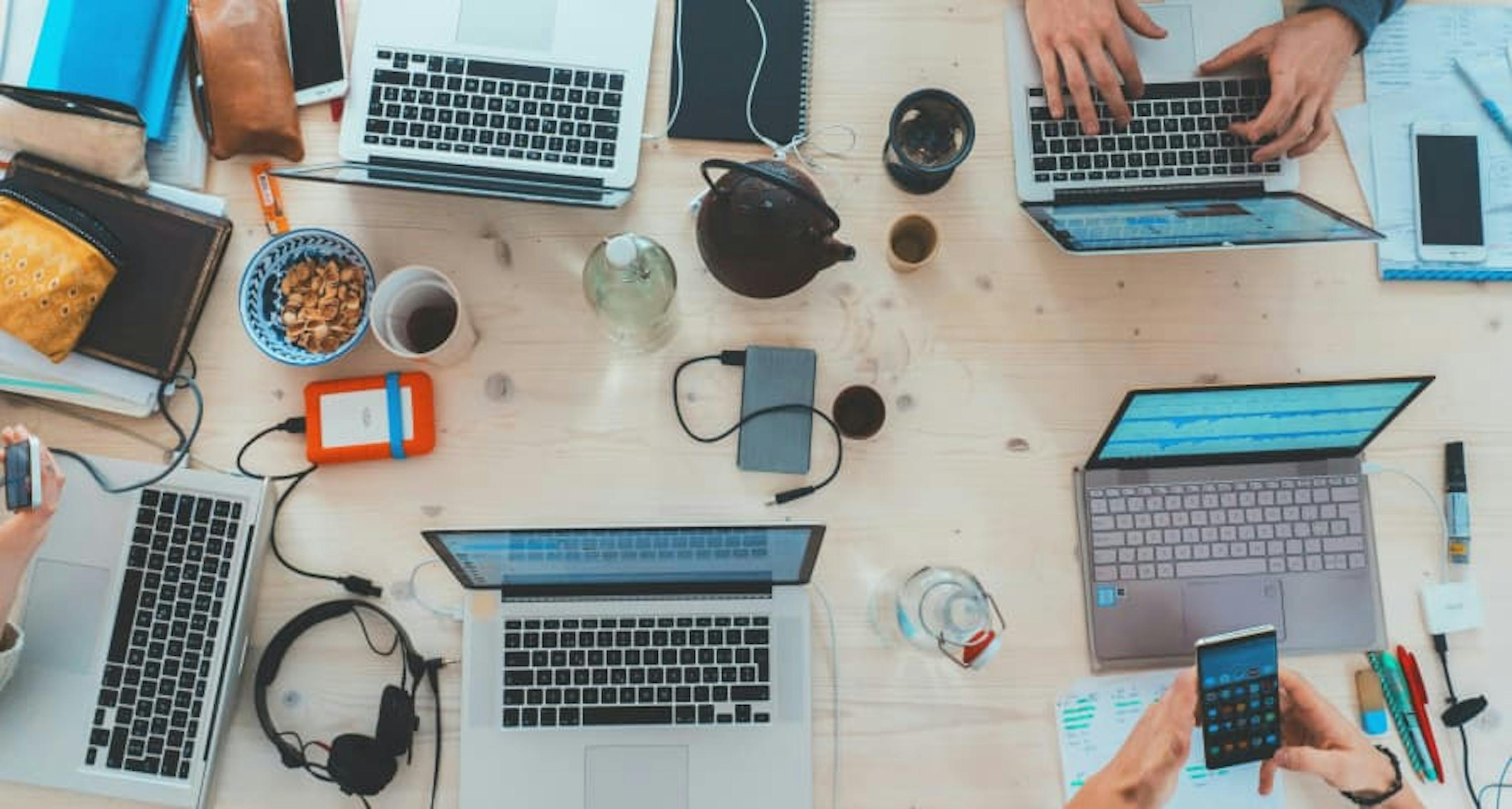 people with laptops, phones, snacks from bird's eye view