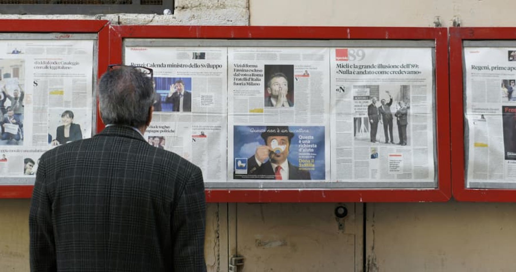 man in suit looking at newsboard