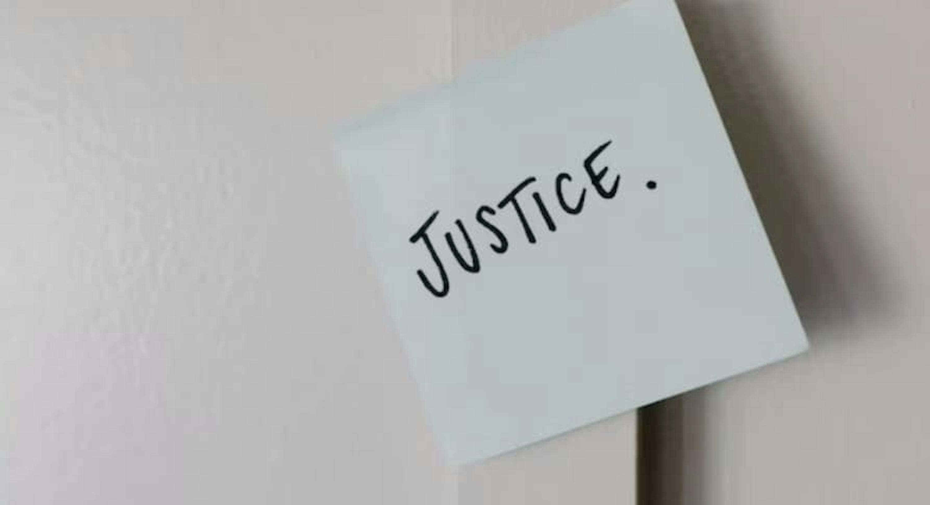 a paper on the wall with the word justice