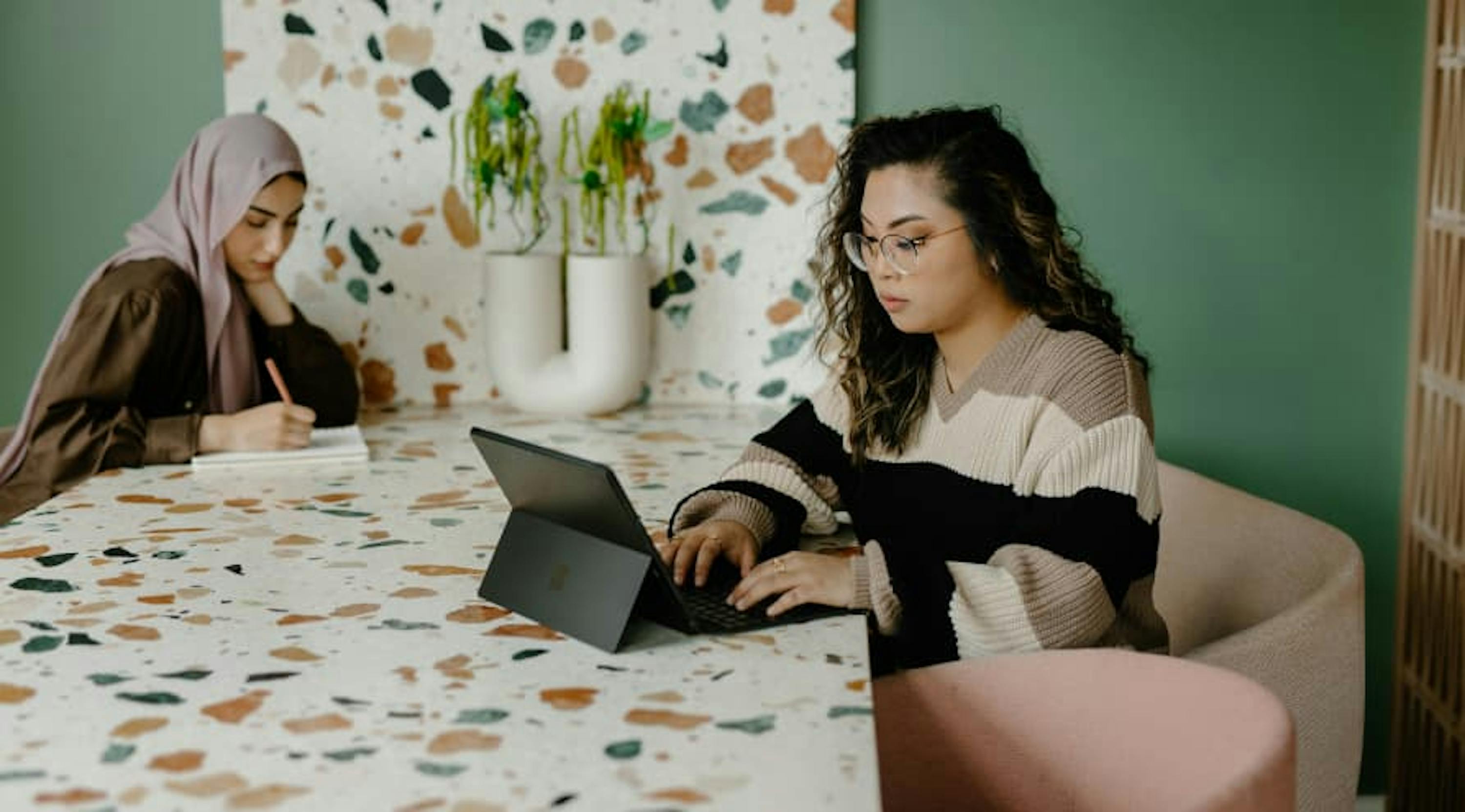 young workers in co-working space with plants and modern furniture