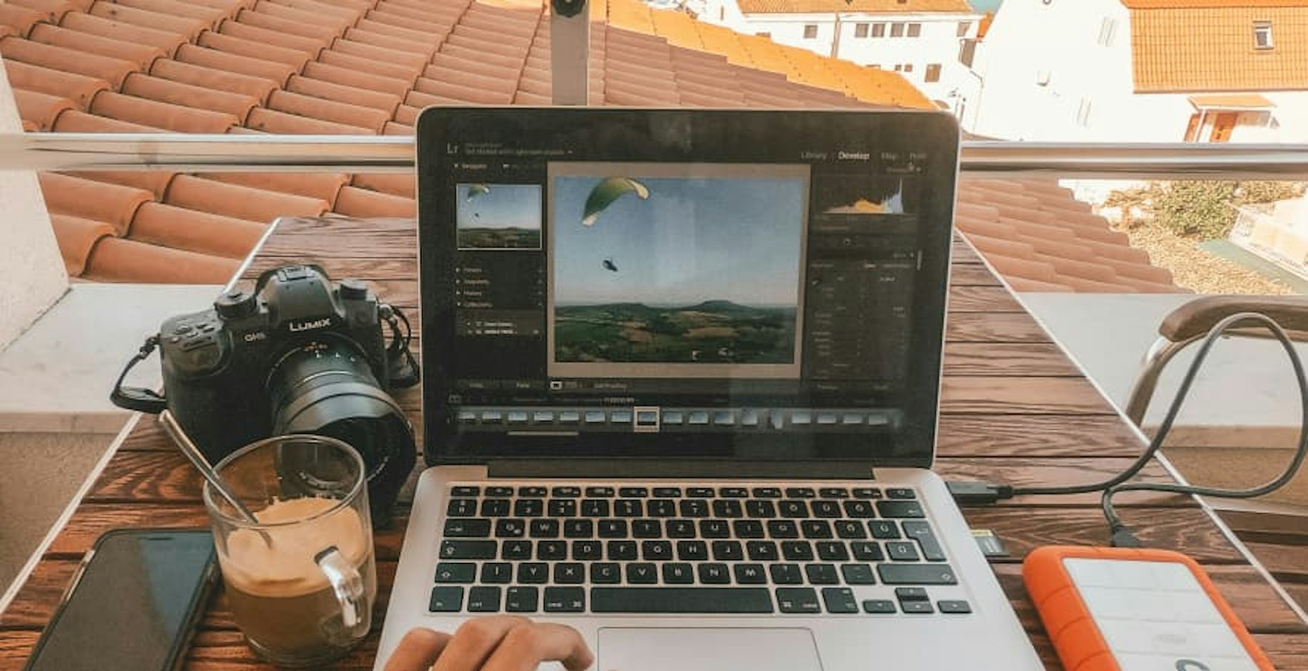 digital nomad working from laptop with coffee and camera