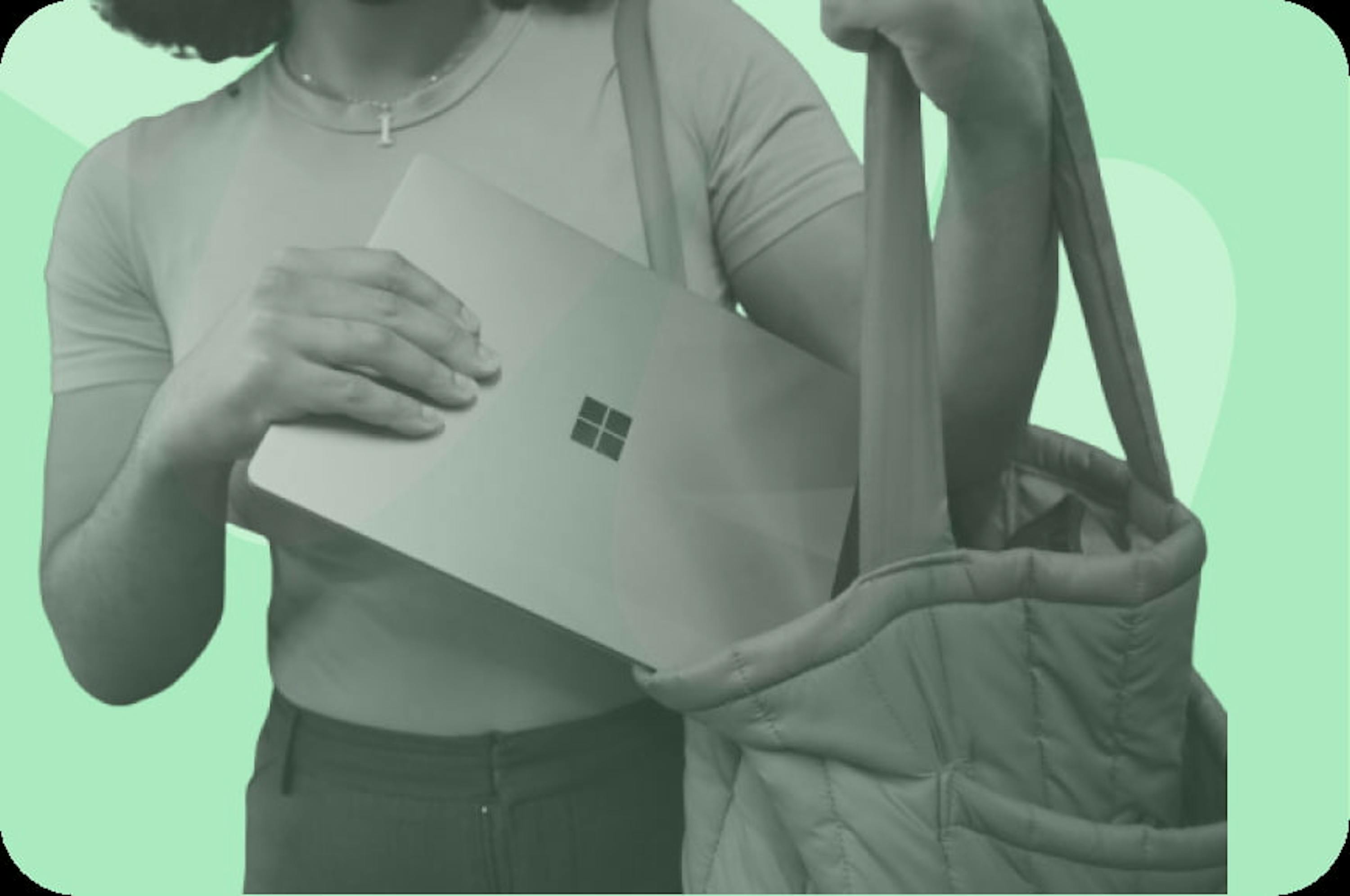 person putting a microsoft laptop in bag