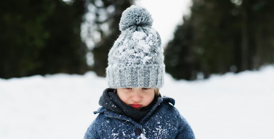 toddler with winter beanie in the snow