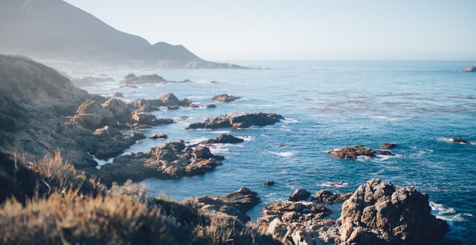 rocky coastline with mountains and clear blue water