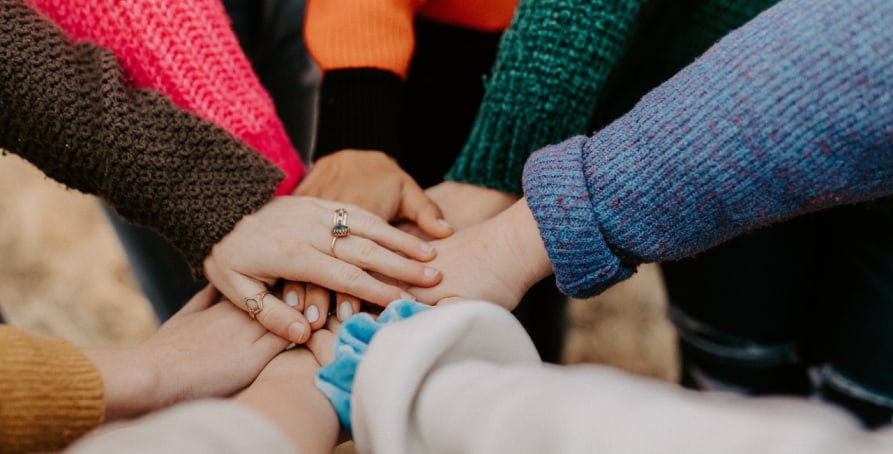 people putting in hands together