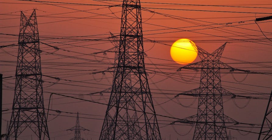 electricity pylons in front of a sunset 