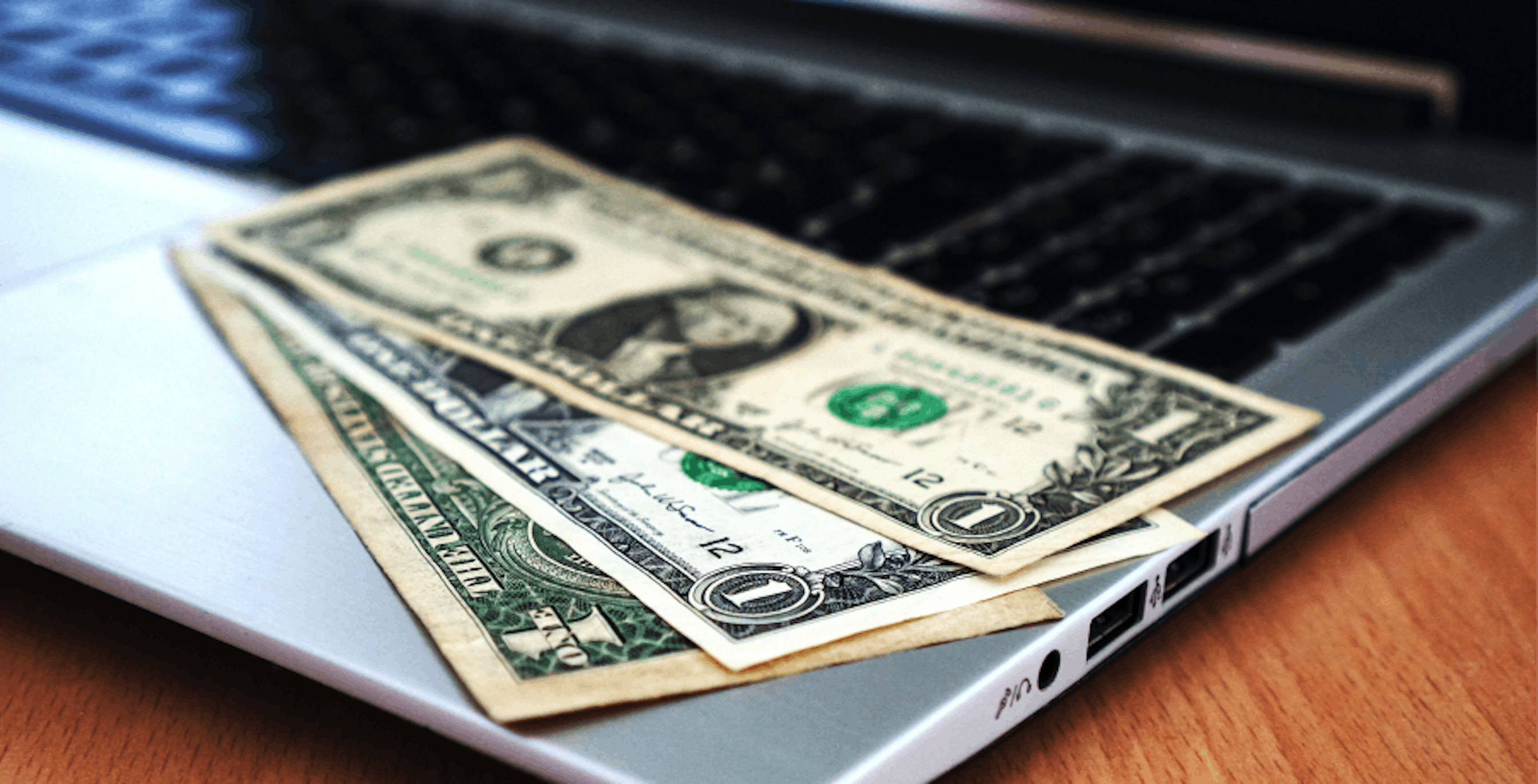 $1 USD bills on laptop