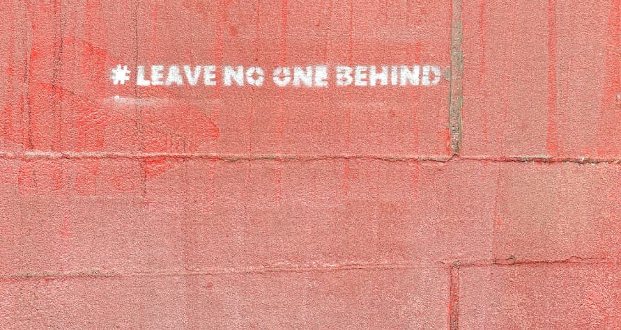 a wall that reads 'leave no one behind'