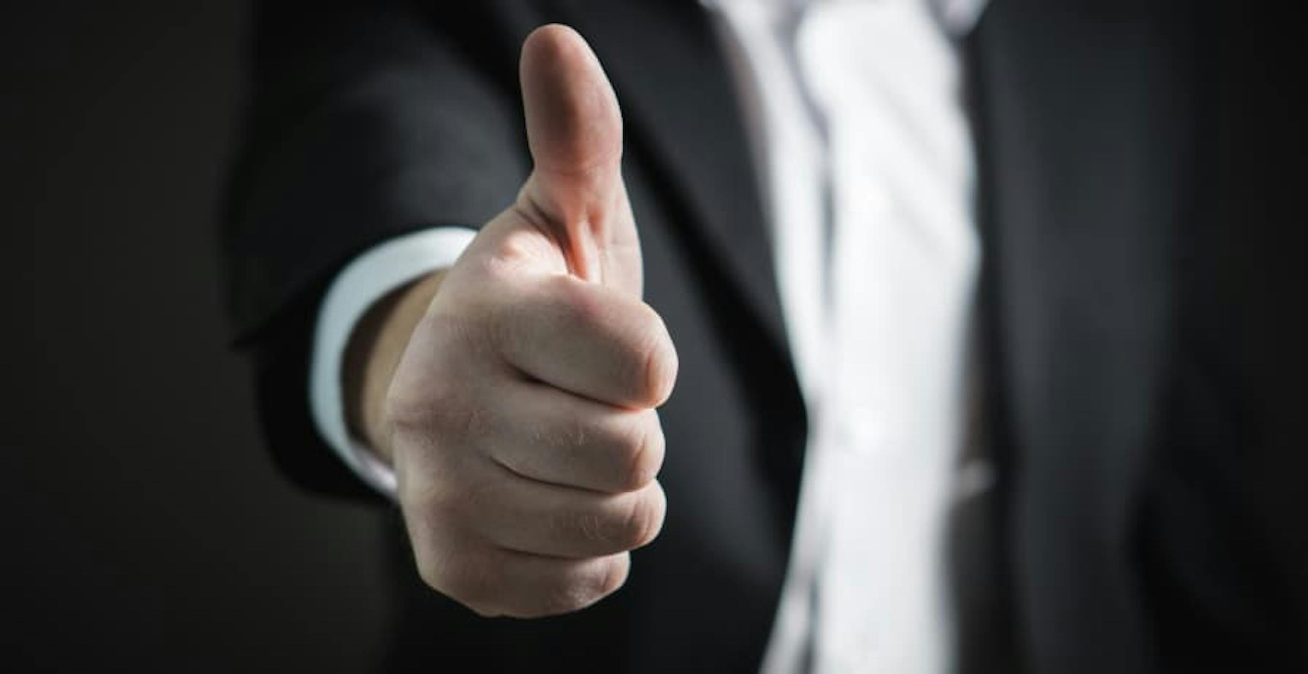 guy in suit giving a thumbs up