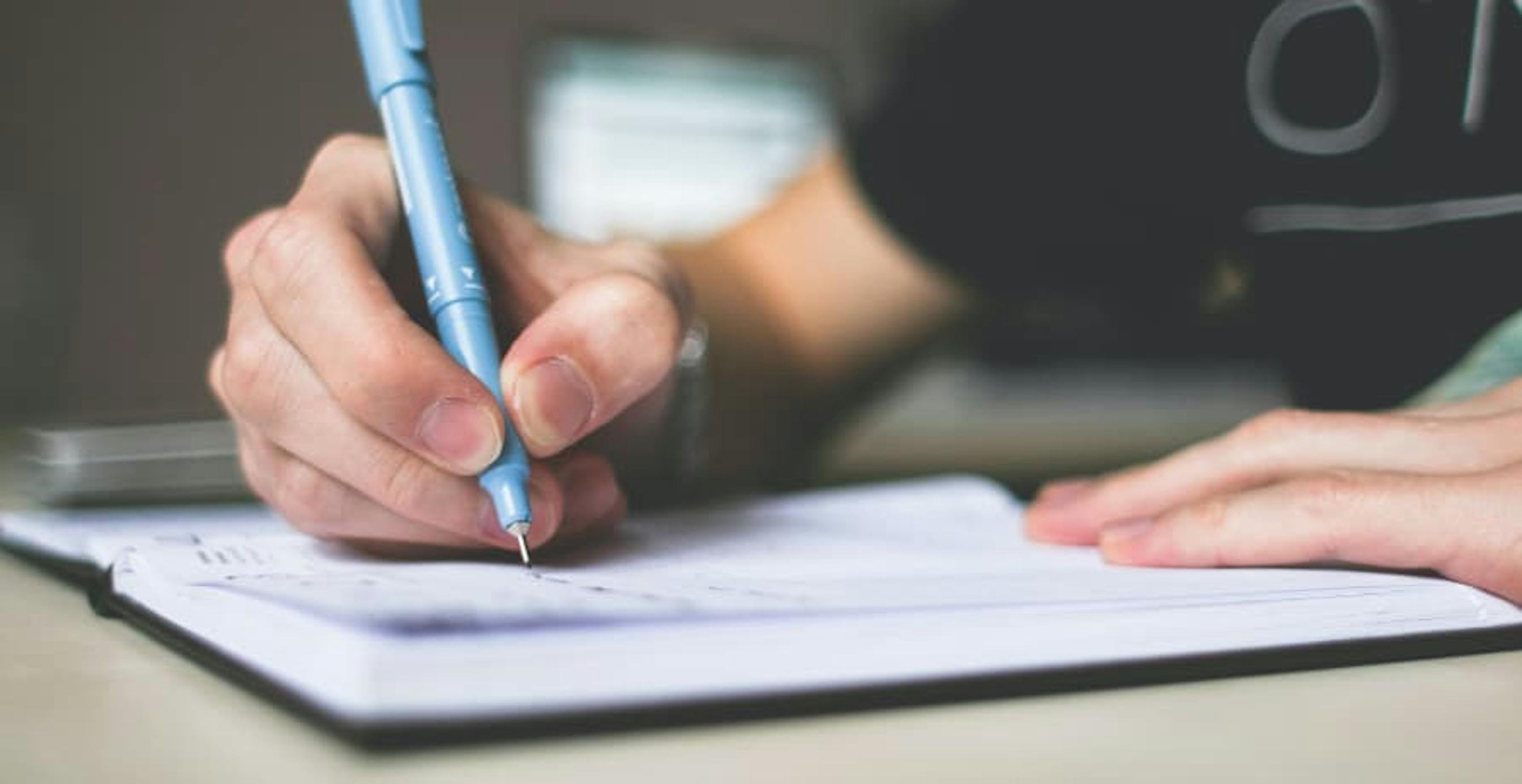 person making a list in a notebook