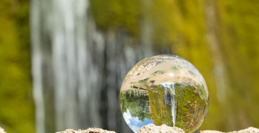 clear glass ball with waterfall behind