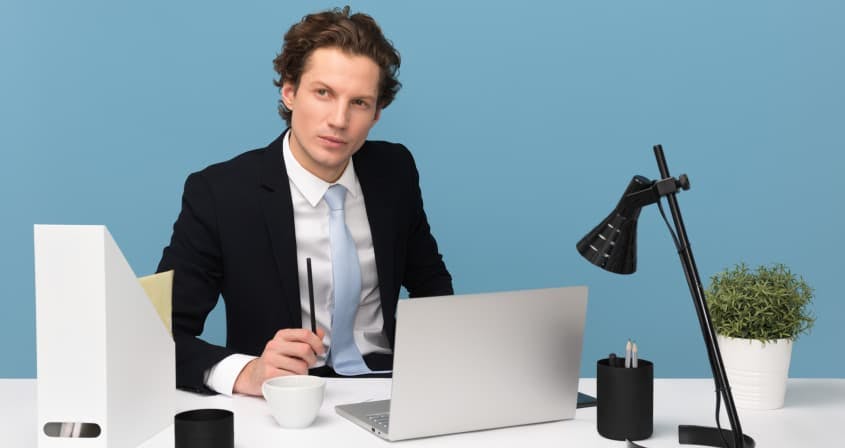 man in suit working from desk