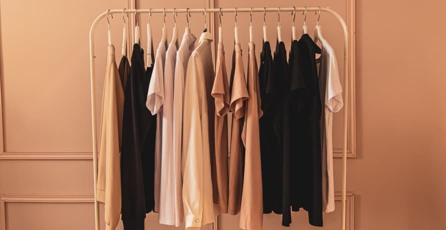 basic colored clothes in dim room on rack
