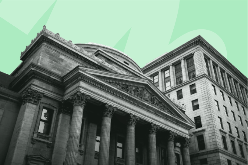 Façade d'une ancienne banque en pierre, avec colonnes et fronton sculpté, typique de l’architecture du XIXe siècle