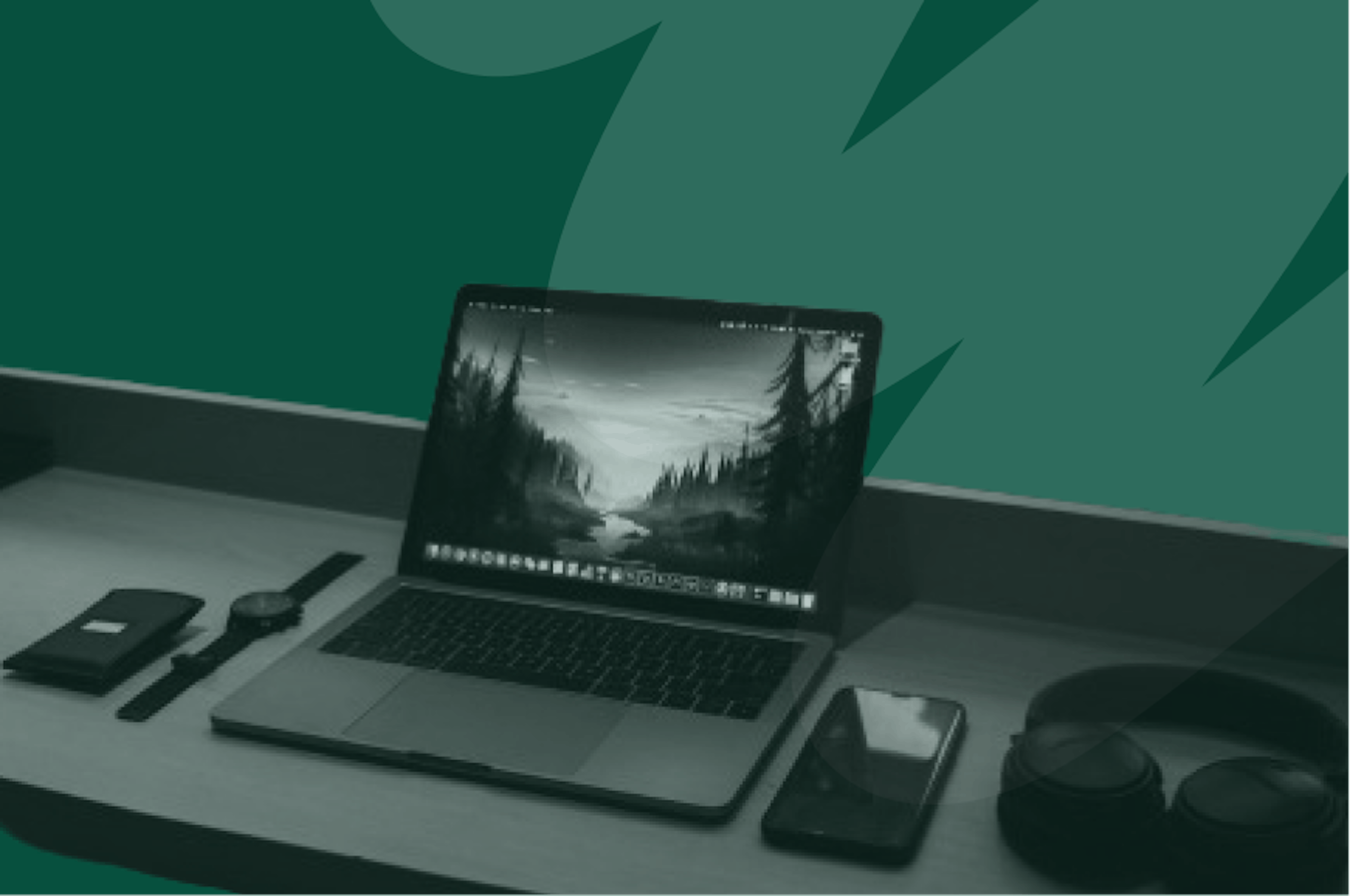 laptop on desk with phone and headphones