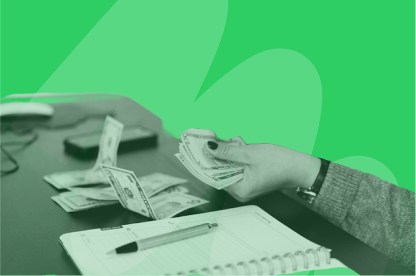 person counting cash at desk