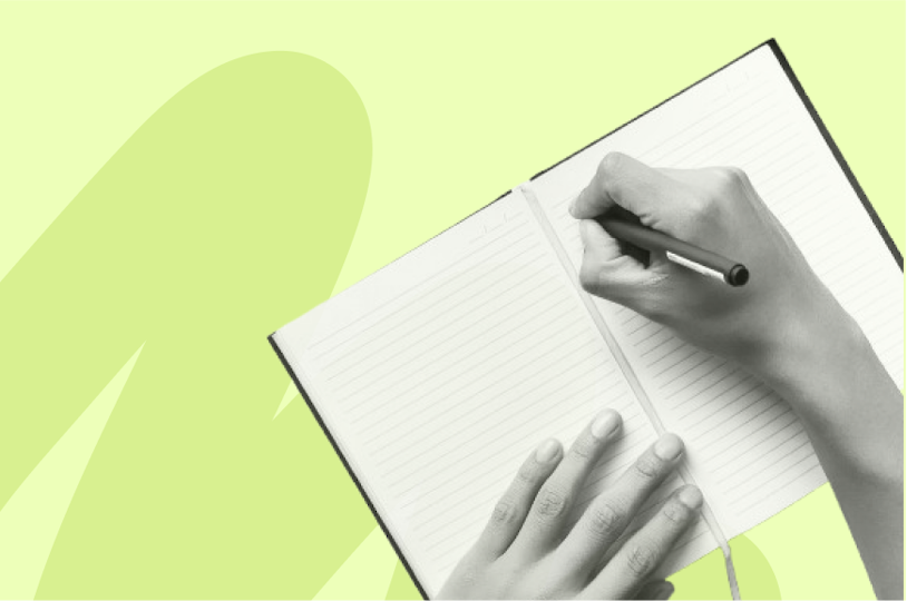 Personne écrivant avec un stylo sur un cahier