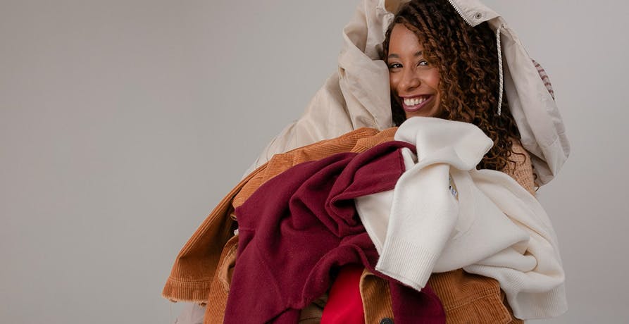 une femme couverte de vêtements en vrac