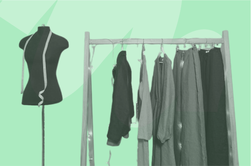 black mannequin with yellow tape measure and clothes on rack