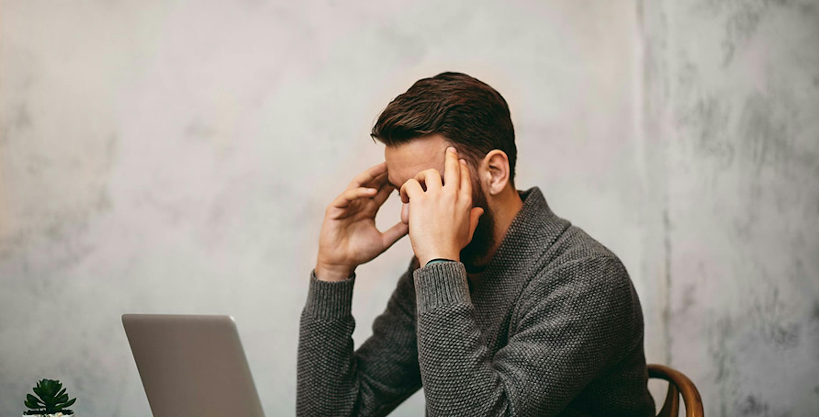 un homme qui se tient la tête