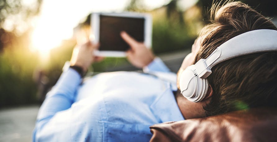 un homme allongé avec sa tablette