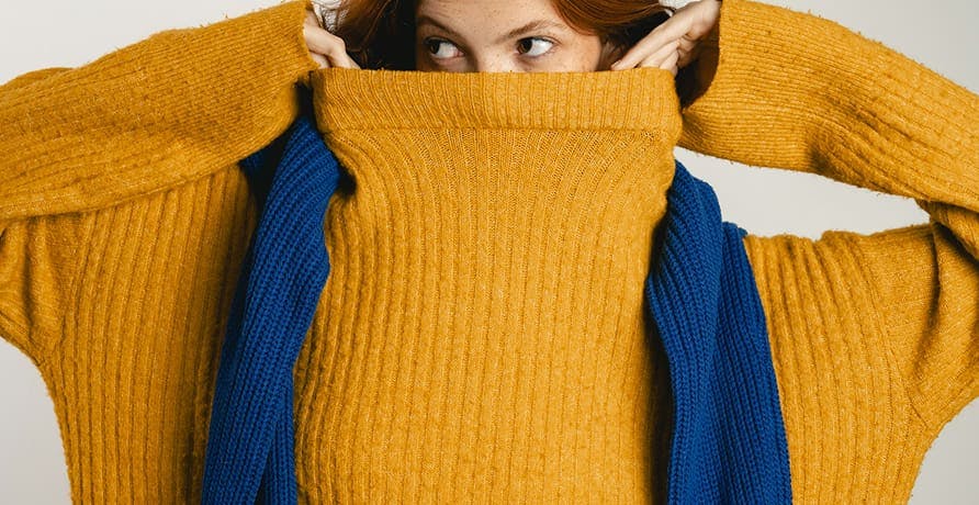 une personne cachée dans un col roulé