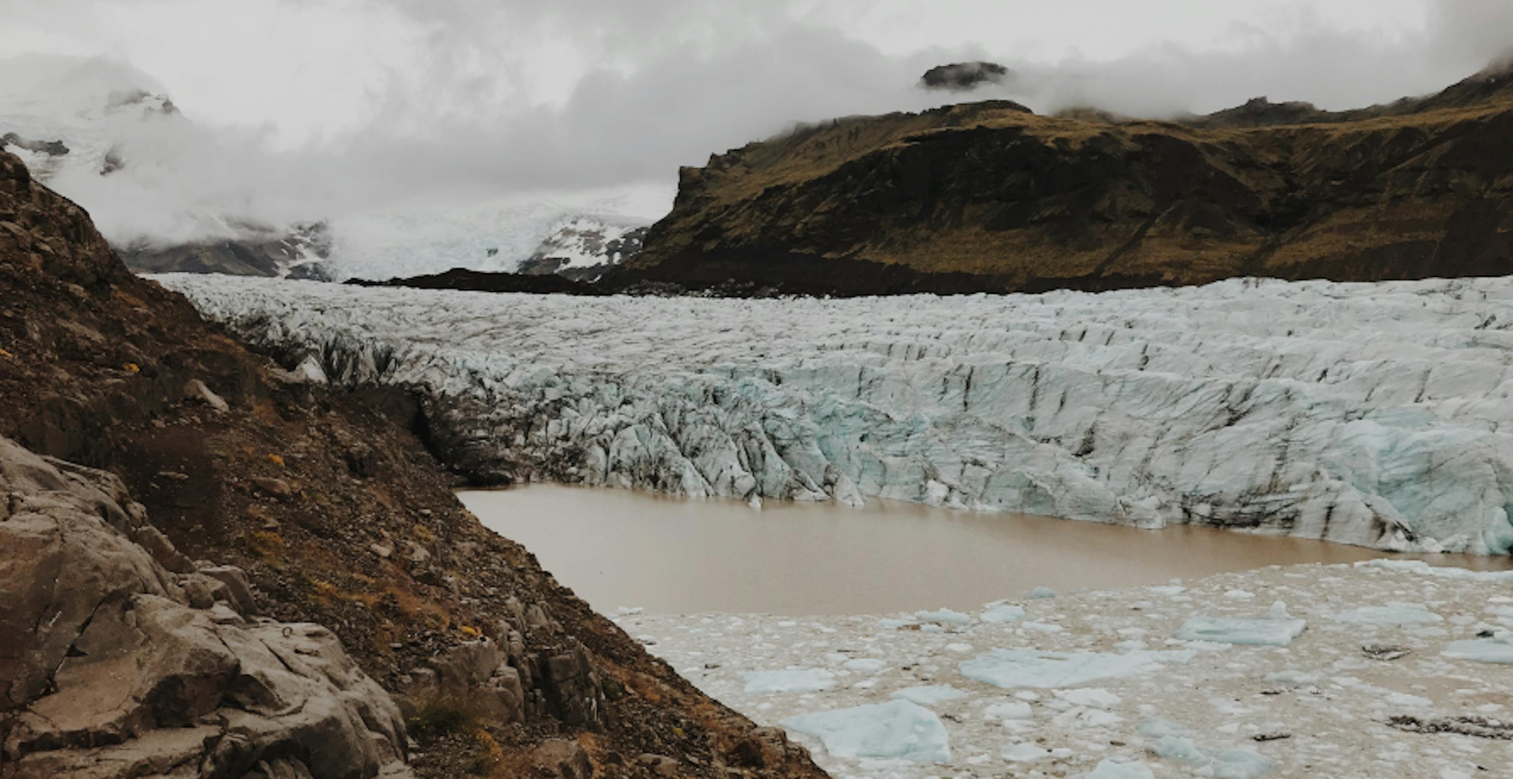 Glacier with ash in the ice with melted water