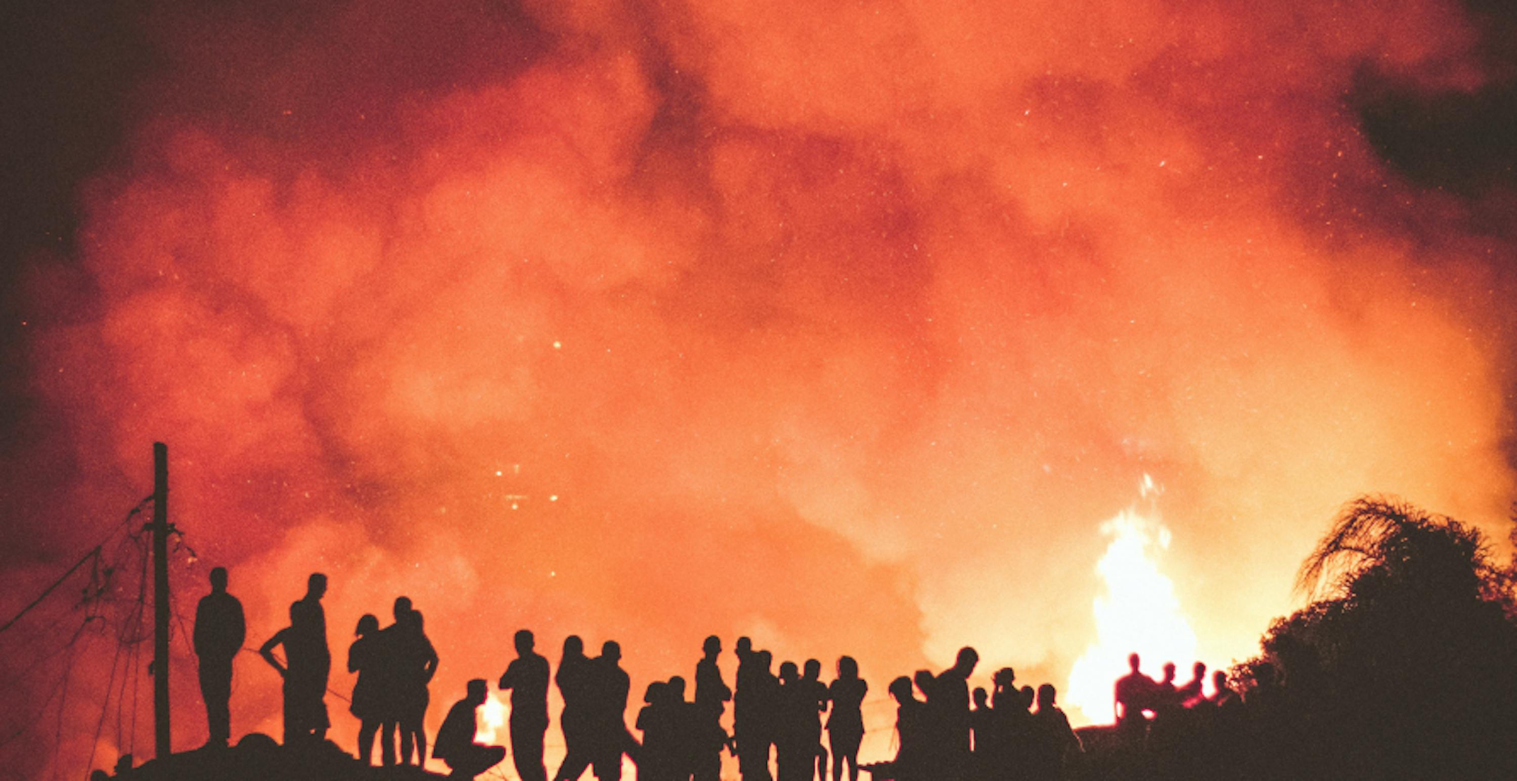 des personnes devant un paysage en flamme