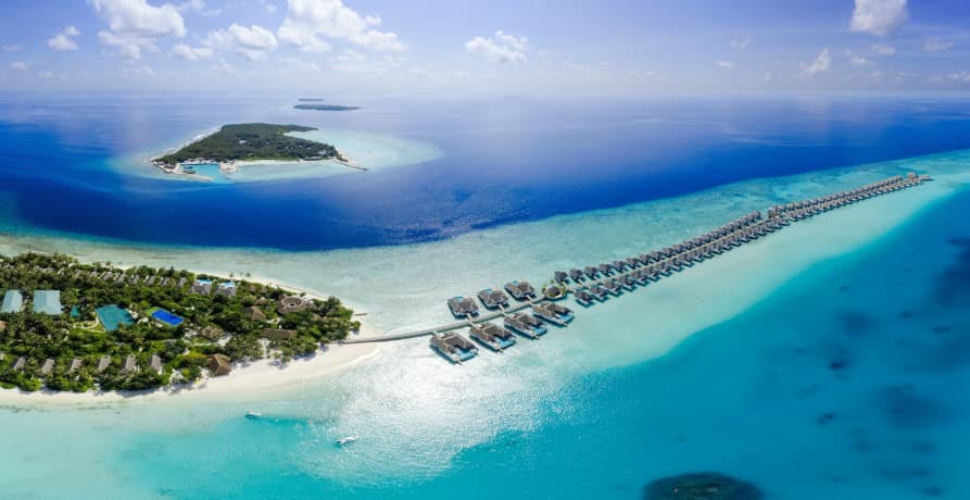 arial shot of Maldives island resort with lots of water bungalows