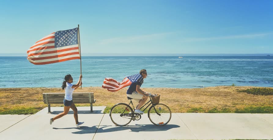 people running and biking with american flag