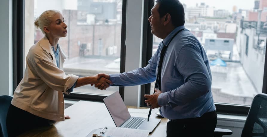 two people in business attire shaking hands