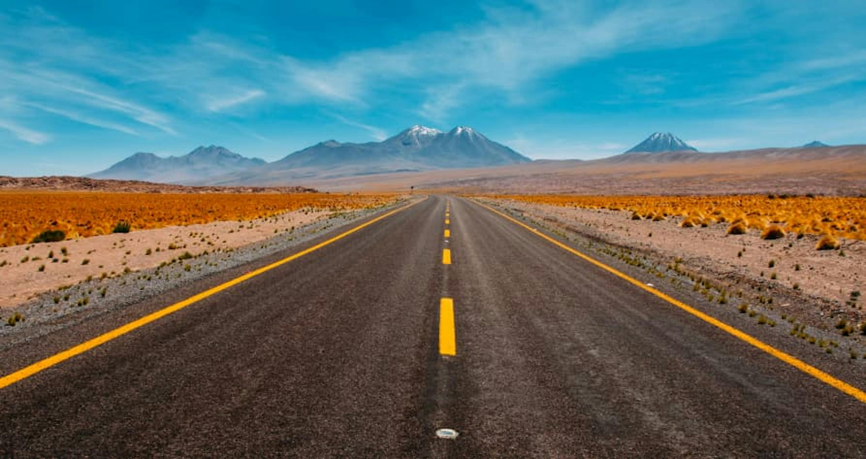 open road mountain ahead blue sky