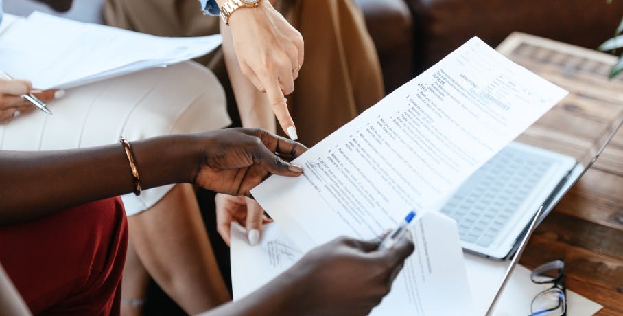 personne pointant du doigt une feuille